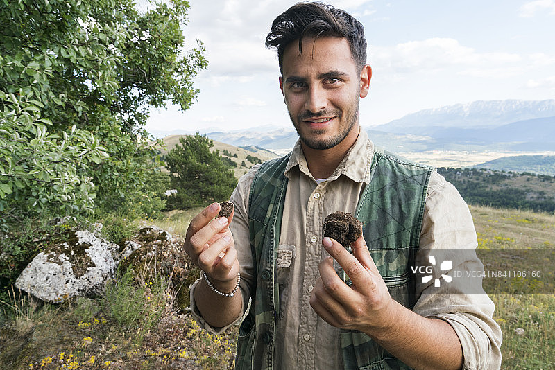 松露猎人与狗在森林中展示松露图片素材