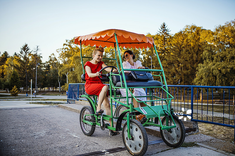 年轻女性朋友骑着四轮车玩耍图片素材