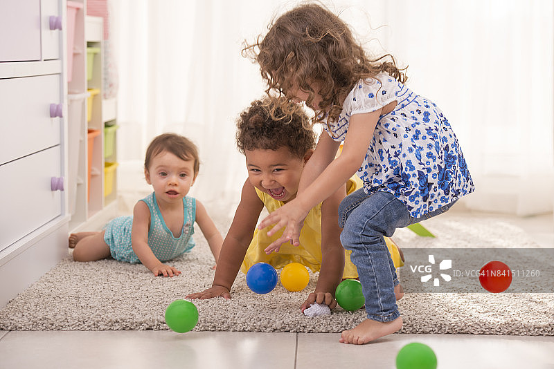 在儿童房里一起玩耍的三个小女孩图片素材