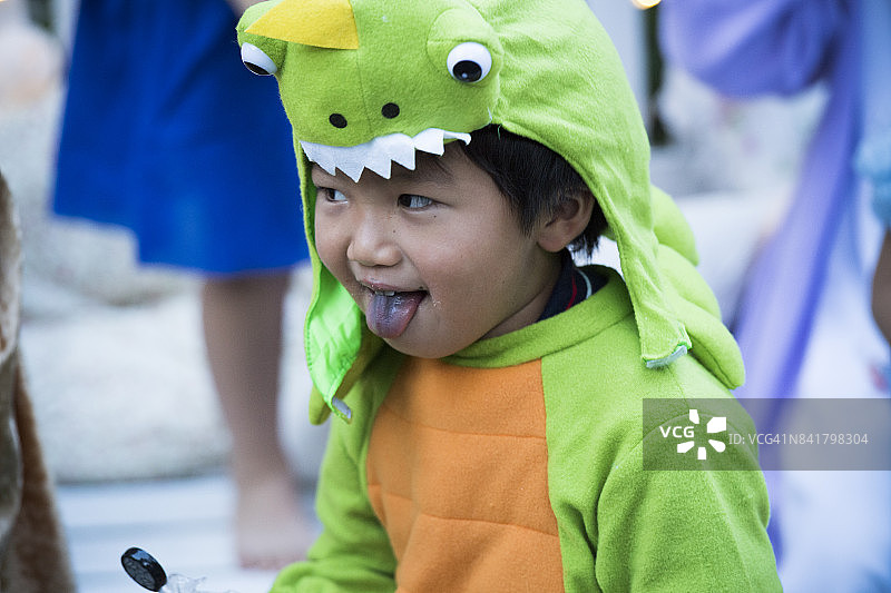 男孩穿着恐龙服在外面恶作剧图片素材