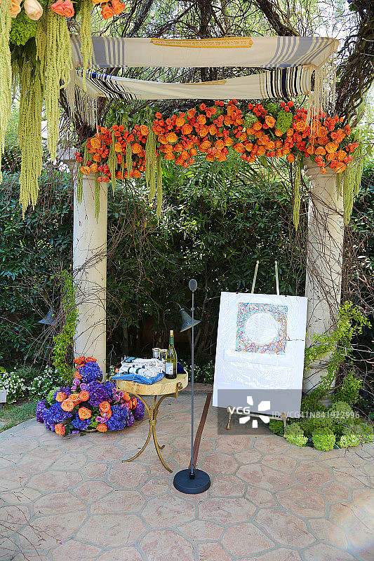 鲜花、红酒和犹太结婚证书装饰的婚礼拱门图片素材