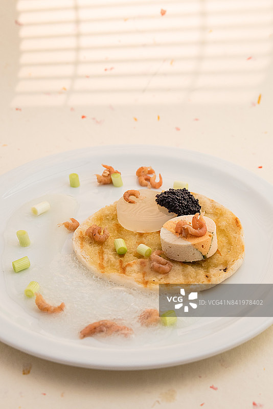 鱼肉冻糕配鱼子酱、虾、扇贝、烤面包、泡沫、凝胶和酱汁图片素材