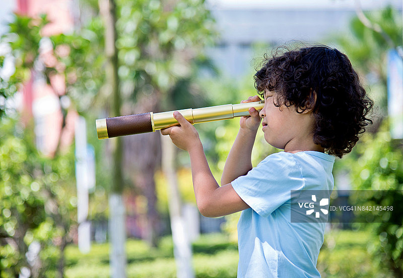 小男孩在公园里拿着望远镜图片素材