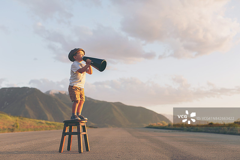 小男孩推销员用扩音器传递信息图片素材