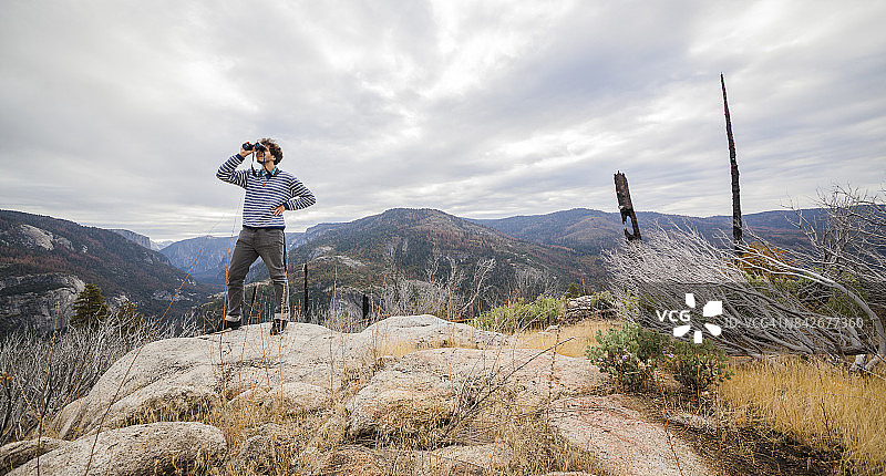 25岁青年在优胜美地国家公园用双筒望远镜观察自然图片素材