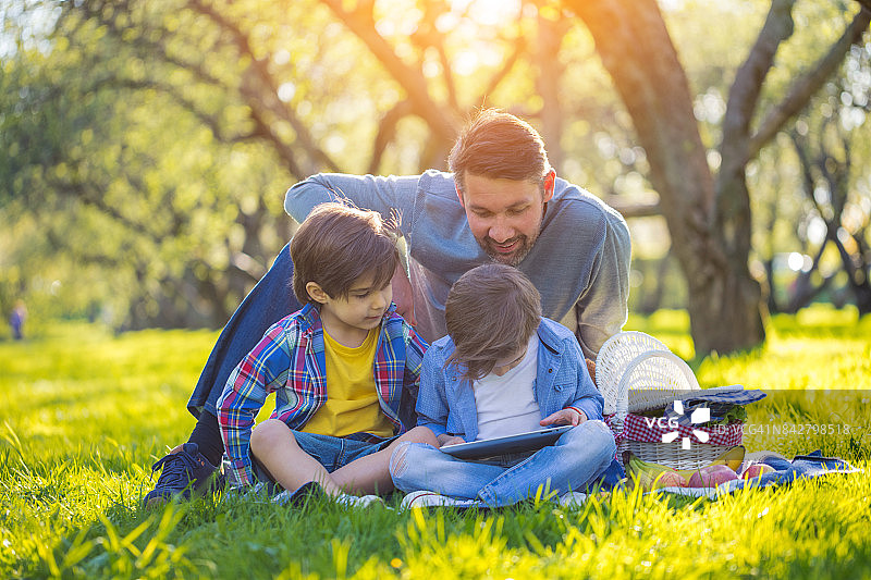 父子在日落时分的公园踢足球图片素材