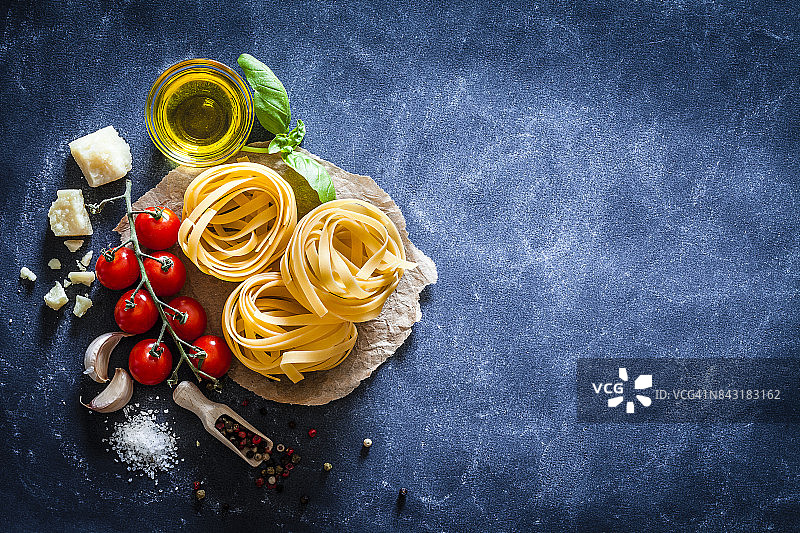 深色桌面上配有食材的意大利宽面图片素材