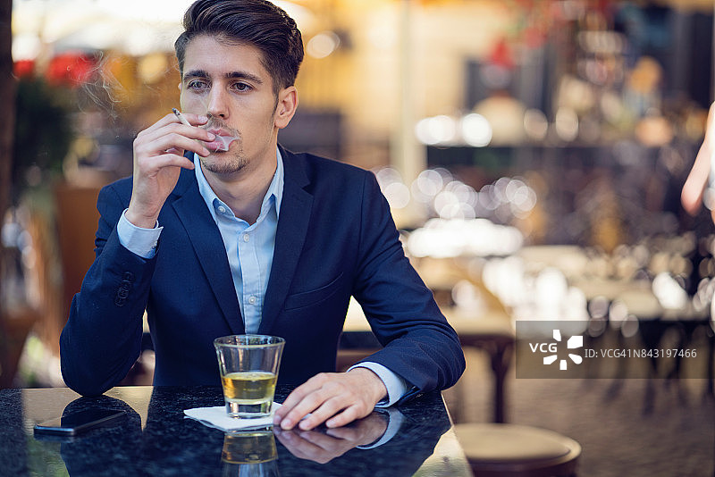 英俊的年轻商人吸烟喝酒图片素材