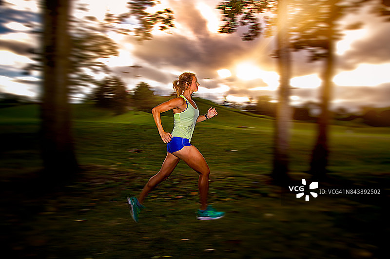 黄昏时分跑步的健康女性图片素材