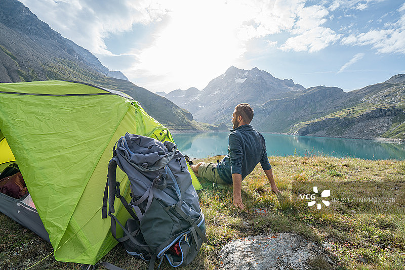 徒步旅行者在露营地旁放松身心，欣赏湖景图片素材