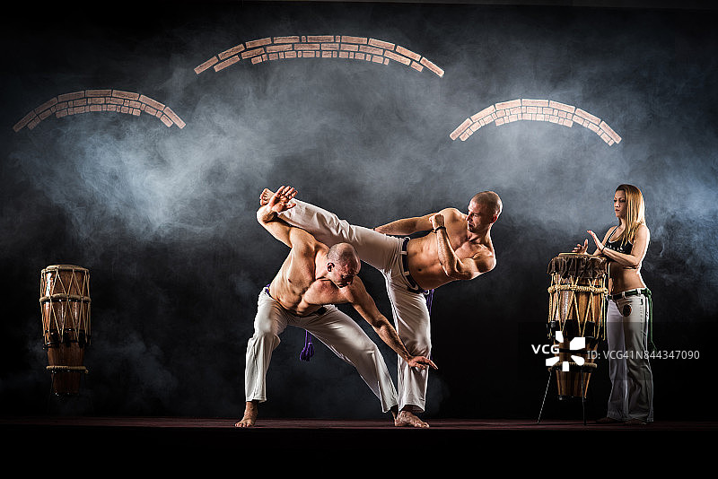 卡波耶拉舞者在体育训练中伴随音乐格斗图片素材