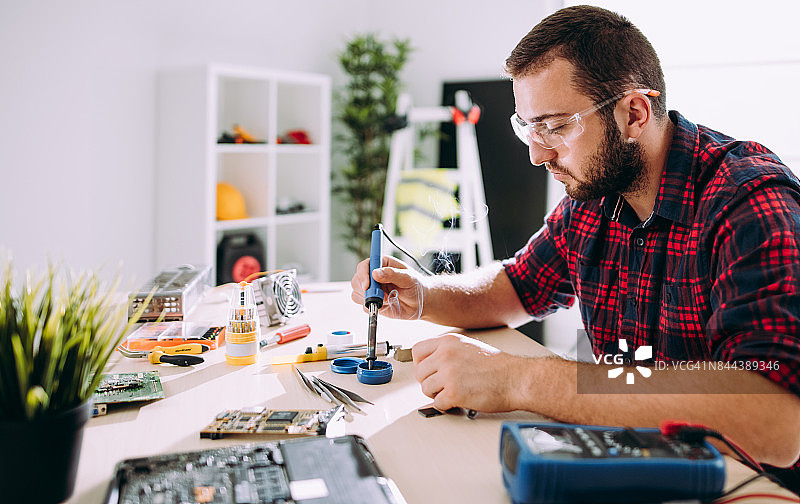 正在焊接电路板的维修工人图片素材