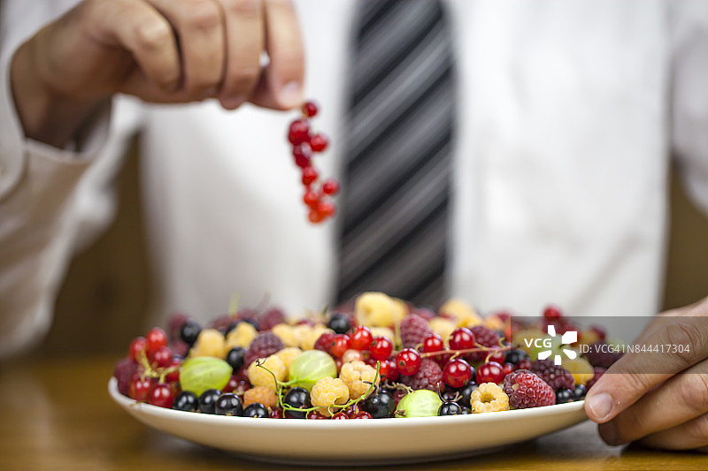 商人工作时吃健康食品，白色盘子里的夏季浆果图片素材