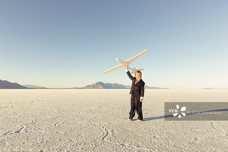 拿着玩具飞机的年轻商务男孩图片素材