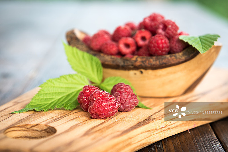 木质背景上的野生覆盆子与叶子图片素材