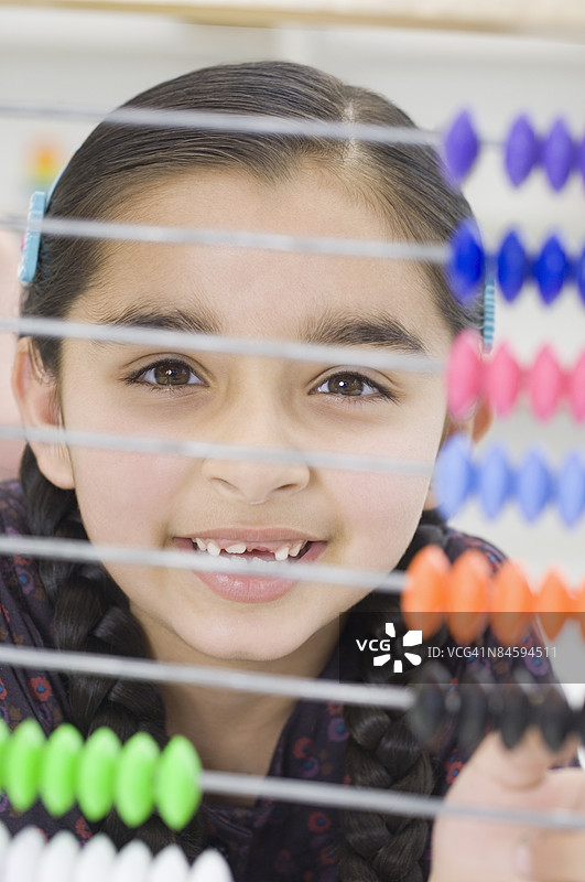 一个女孩在算盘后面微笑的肖像图片素材