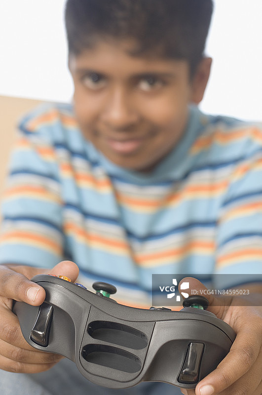 玩电子游戏并微笑的男孩的肖像图片素材