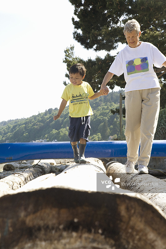 女人和她的孙子在木头上行走图片素材