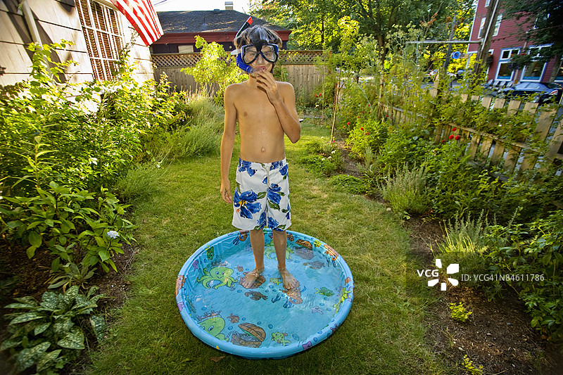 男孩戴着呼吸管站在戏水池里图片素材