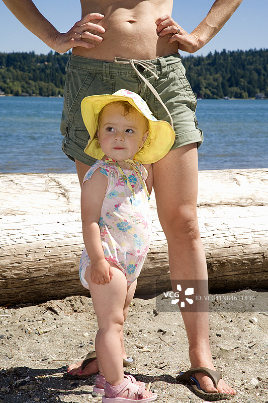 小女孩和她的母亲在海滩上站着图片素材