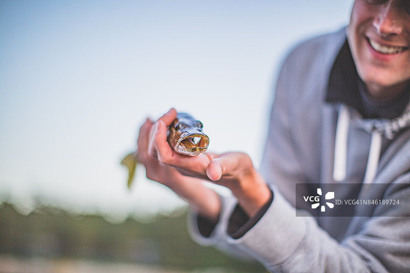 男人拿着一条鱼图片素材