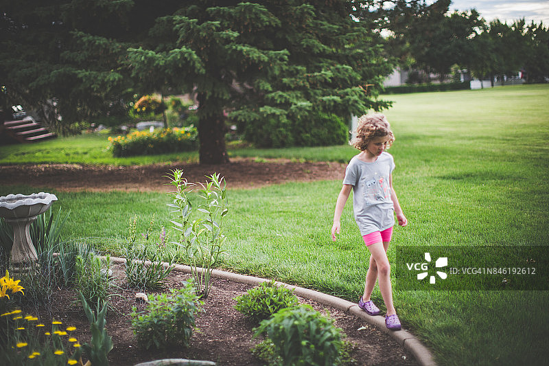 小女孩在花园里散步图片素材