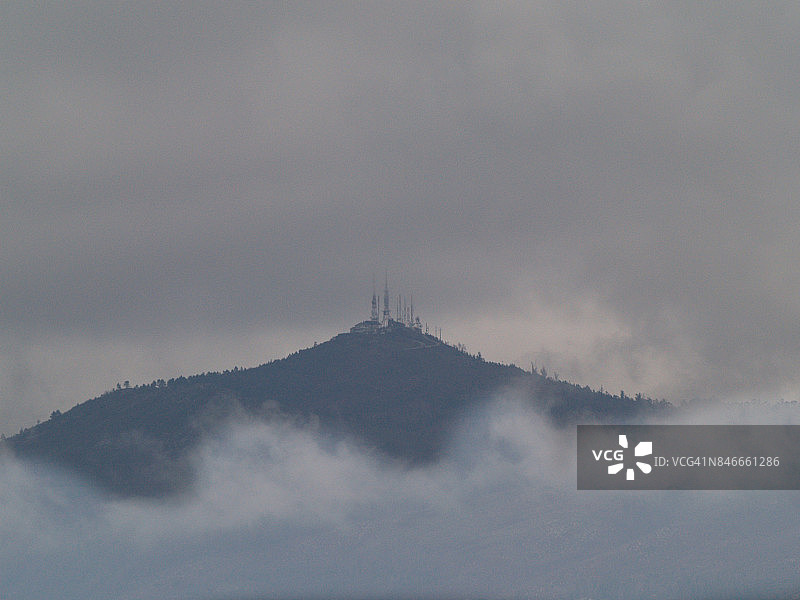 云雾缭绕的山上的通信塔和天线图片素材