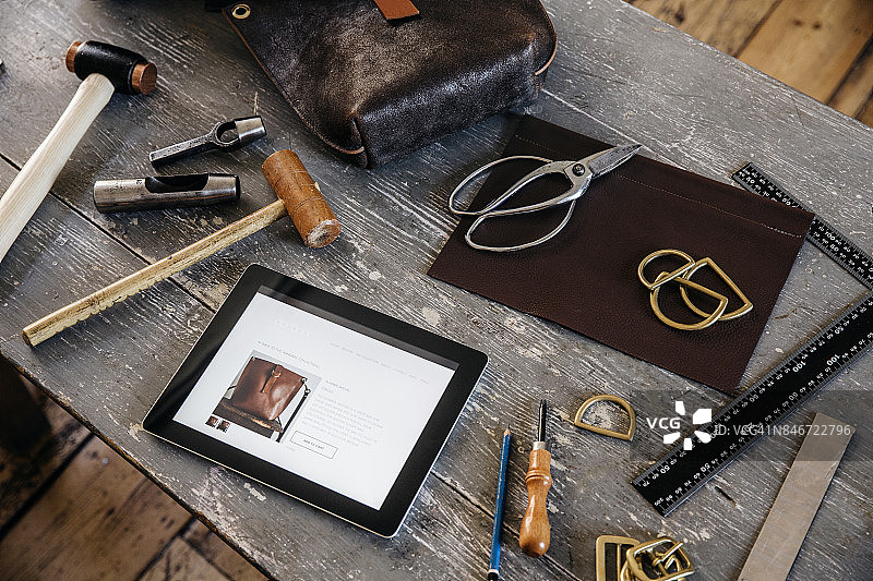 工匠在工作台上使用平板电脑展示网店图片素材