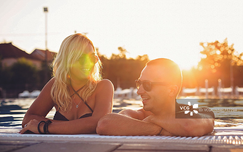 情侣在泳池里嬉戏图片素材