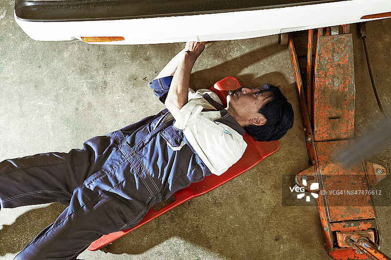 日本汽车修理店里真诚工作的技工图片素材