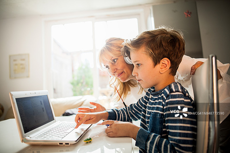 奶奶和孩子使用笔记本电脑图片素材