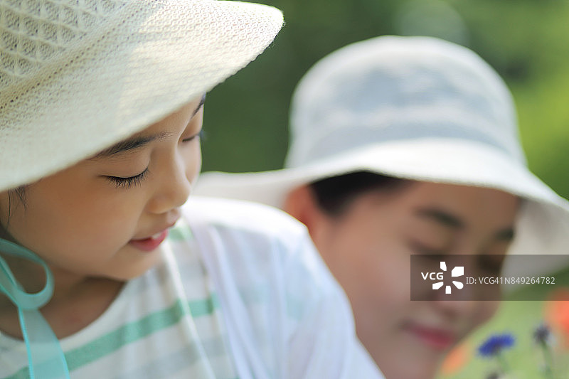 母女在花园里观赏鲜花盛开图片素材