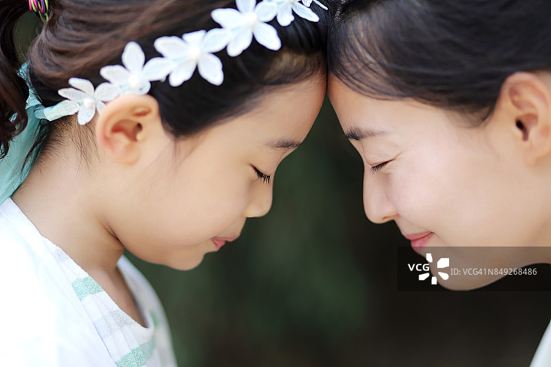 母女闭眼额头相贴的图像图片素材