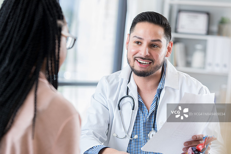 年轻男心脏病专家与患者分享诊断结果图片素材