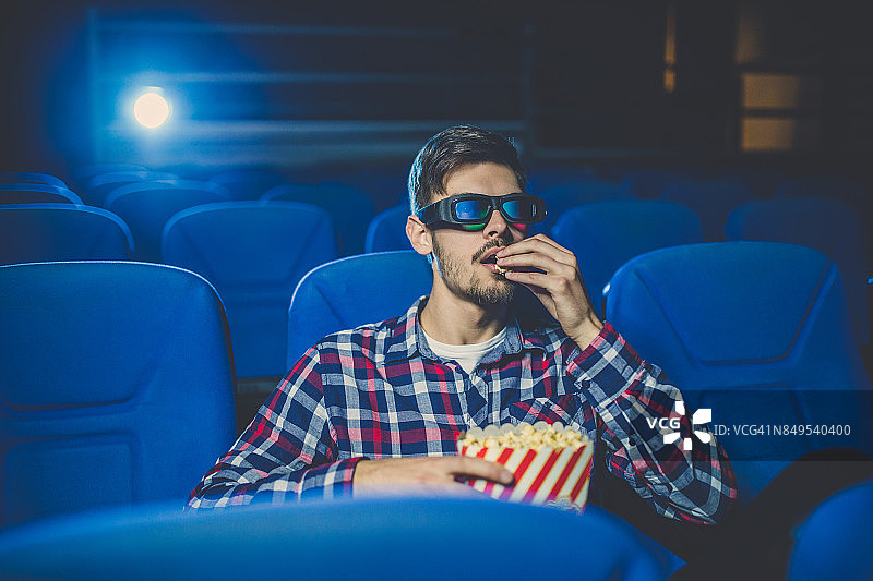 年轻男人在电影院看电影图片素材