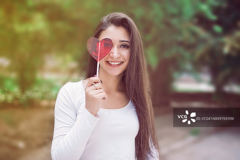 手持红色人造心脏的美丽女人图片素材