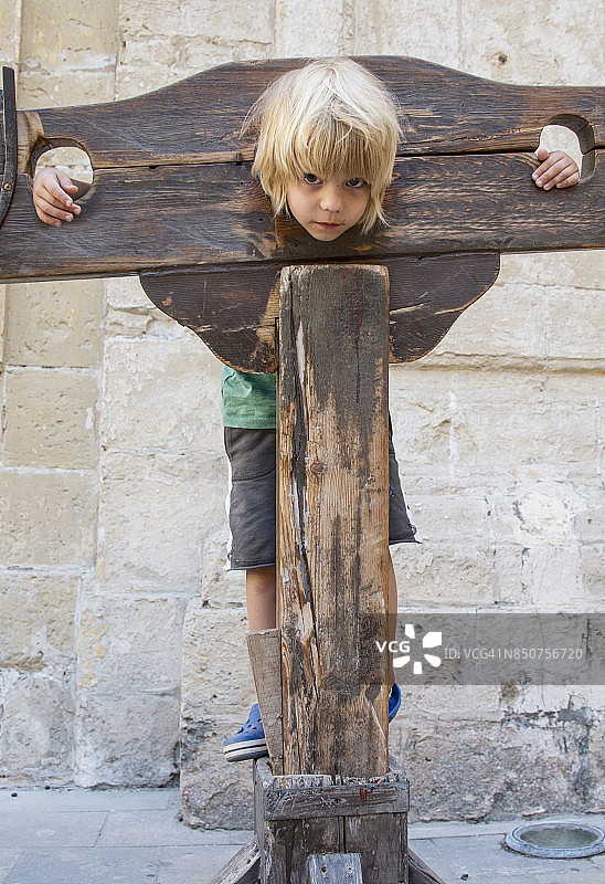 马耳他姆迪纳：被木制示众架困住的小男孩图片素材