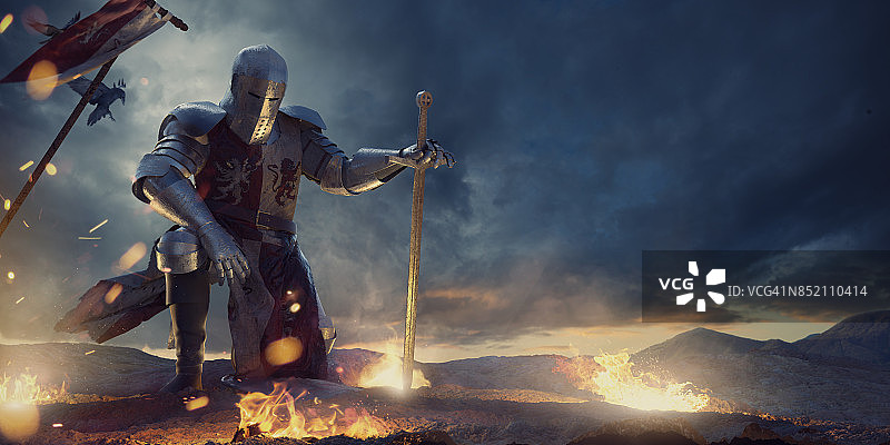 身披盔甲的骑士单膝跪在山顶的篝火旁图片素材