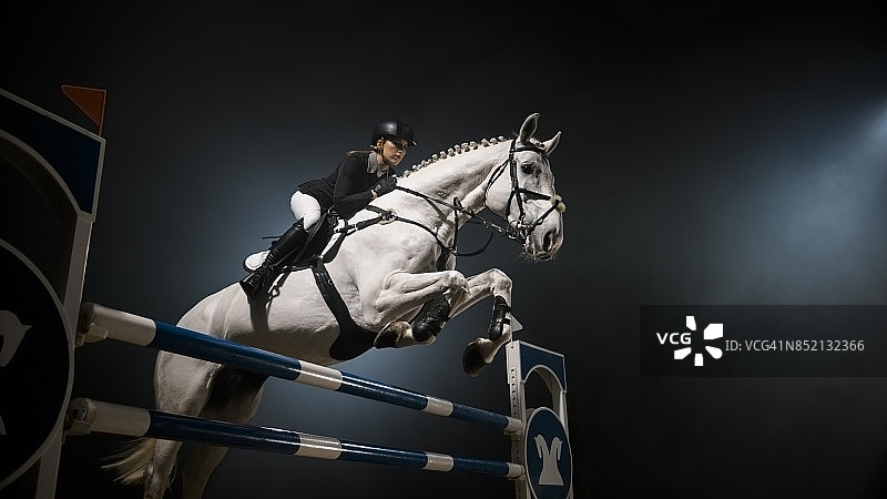 白马跳过竞技场上的栏杆图片素材