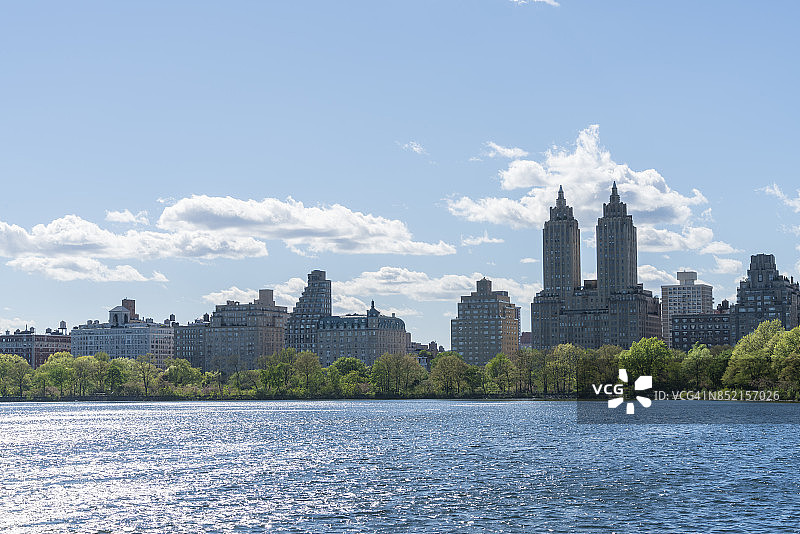 阳光照耀下的纽约中央公园水库波光粼粼，绿树和中央公园西历史街区图片素材