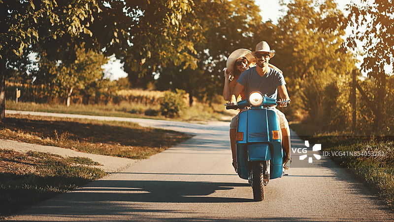 情侣骑着摩托车在乡间行驶图片素材