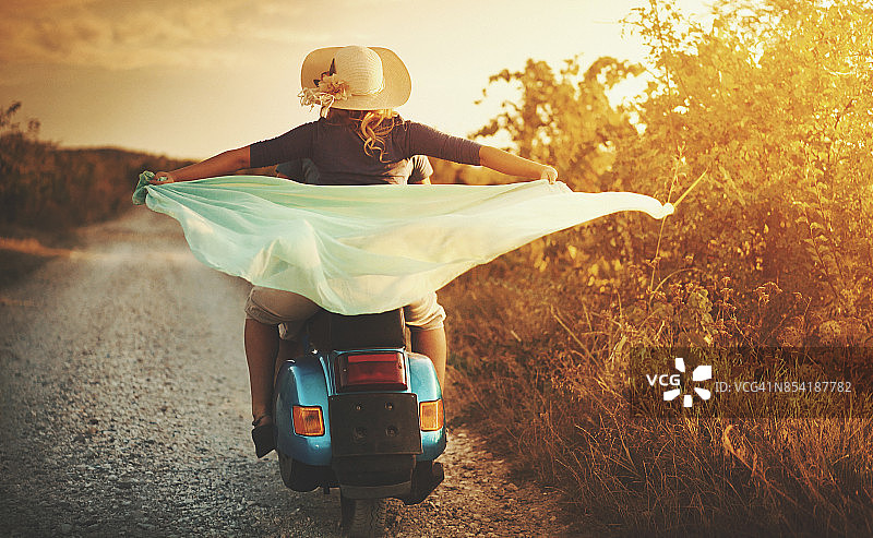 情侣骑着摩托车在乡间行驶图片素材