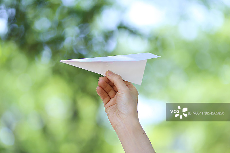 女人手持白色纸飞机图片素材
