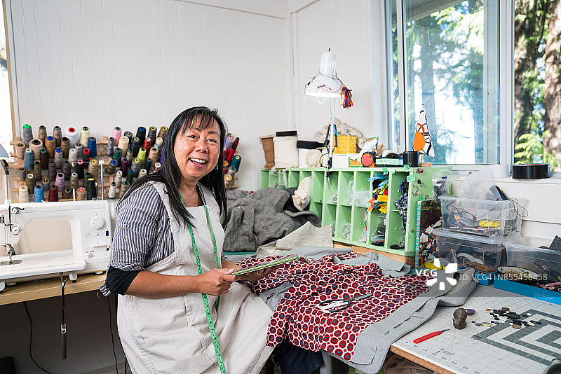 在工作室使用平板电脑的中年纺织品商人图片素材