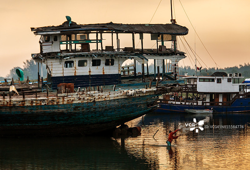 渔夫撒网的造船厂沉船图片素材