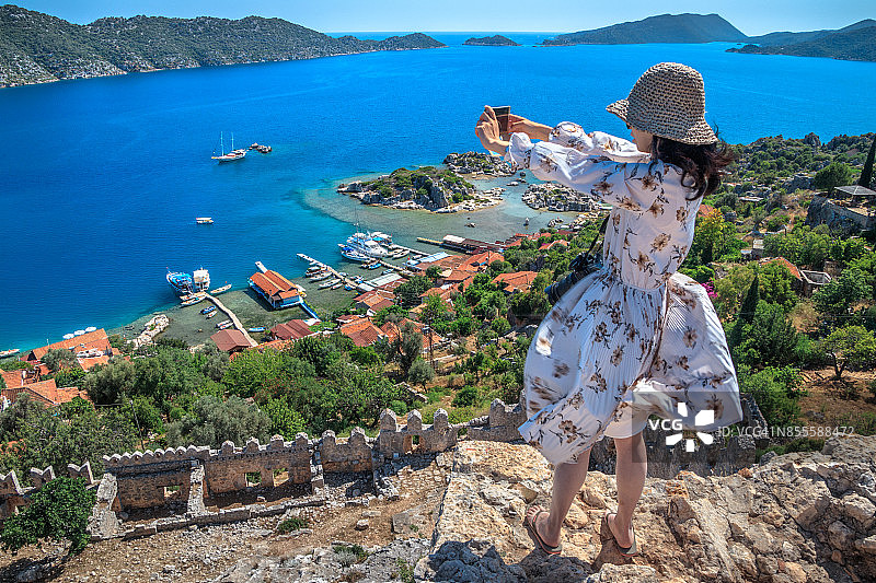 在土耳其安塔利亚卡莱科伊的希梅纳城堡拍照的女性游客图片素材