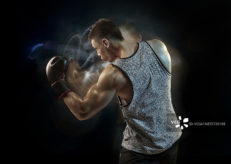 在黑暗健身房里挥拳的健壮男人图片素材
