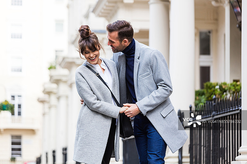 快乐浪漫的夫妇在城市街道上调情图片素材