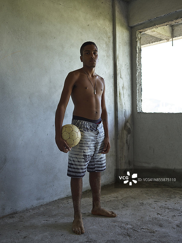 手持足球的年轻巴西男人肖像图片素材