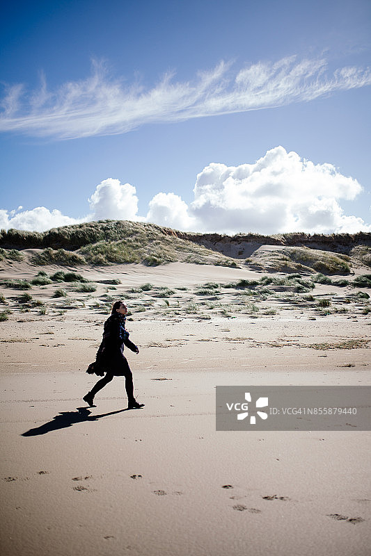 在特塞尔海边散步的女人图片素材